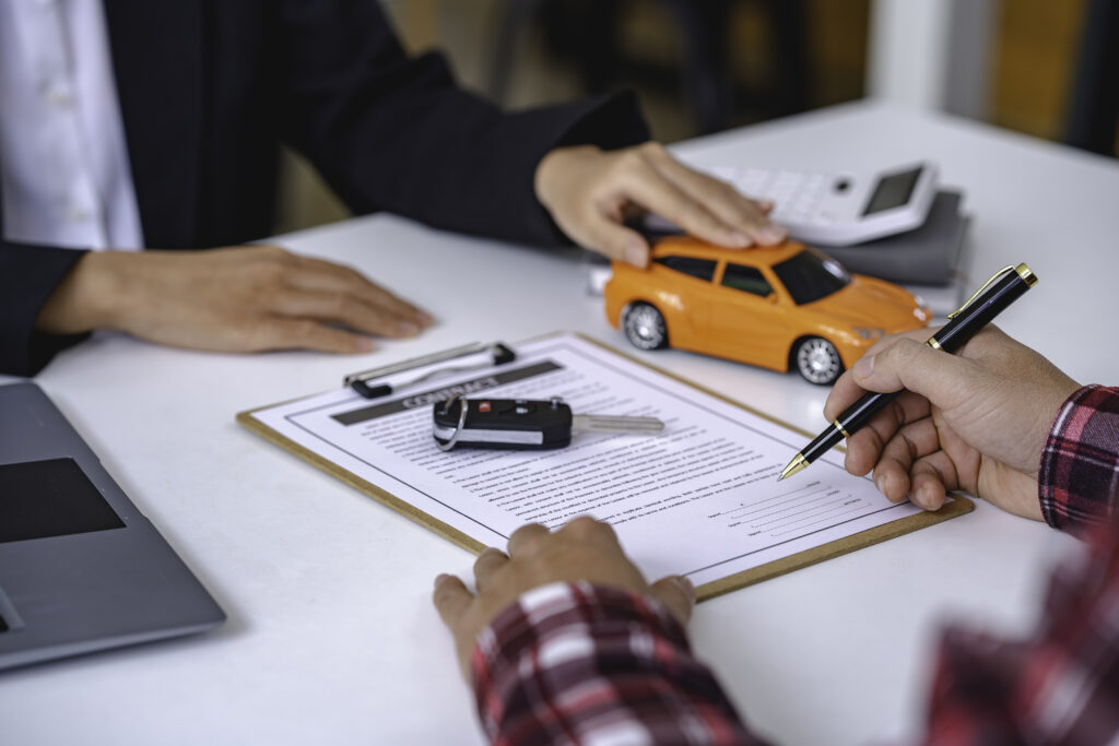 Documente auto, chei și machetă de automobil pe biroul unui consultant